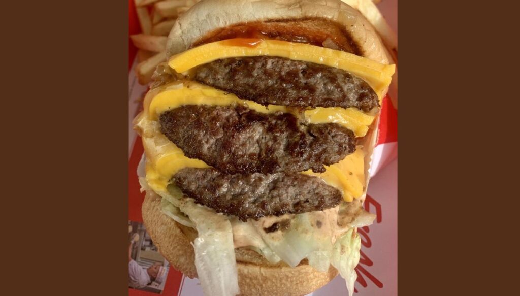 3x3 burger with three slices of cheese and beef patties.